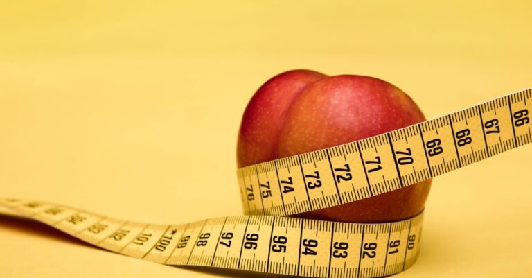 Apel dengan pita pengukur pada latar kuning, simbol pengukuran tubuh dan obesitas