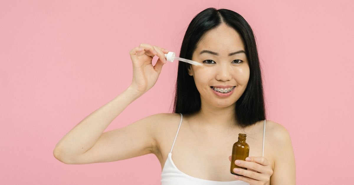 Wanita mengaplikasikan serum pada wajah, hyaluronic acid untuk hidrasi