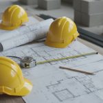 peralatan kontraktor renovasi rumah termasuk helm proyek blueprint dan alat ukur di meja kerja