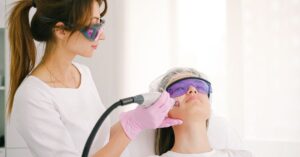 Dokter kecantikan melakukan perawatan laser pada wajah wanita di klinik