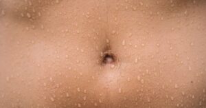 Close-up perut dengan keringat, penyebab miliaria atau biang keringat
