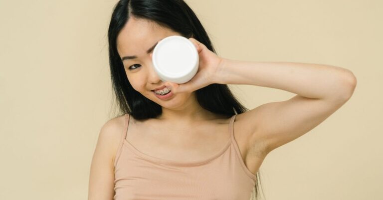 Remaja dengan handuk memegang skincare di wajah, rutinitas perawatan kulit