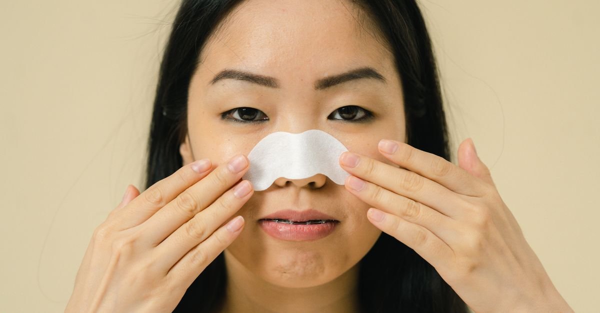 Wanita menggunakan nose strip pada hidungnya, perawatan pori-pori