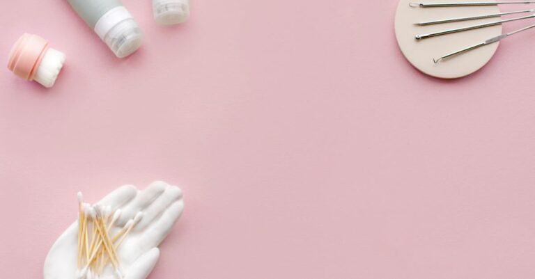 Flatlay produk skincare dan alat kecantikan di latar pink lembut