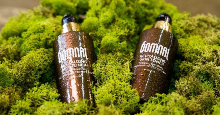 Botol toner pada latar hijau moss, produk toner untuk kulit berminyak
